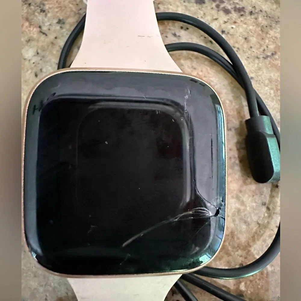 Fitbit versa with pink band and charger